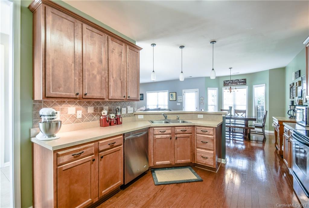 225 Mott Road Mooresville, NC 28115 - Photo 14 of 24 a kitchen with kitchen island granite countertop a sink cabinets and wooden floor