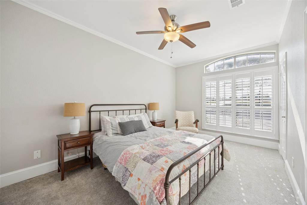 3611 Skinner Road Midlothian, TX 76065 - Photo 21 of 40 a bedroom with a large bed and a chandelier fan