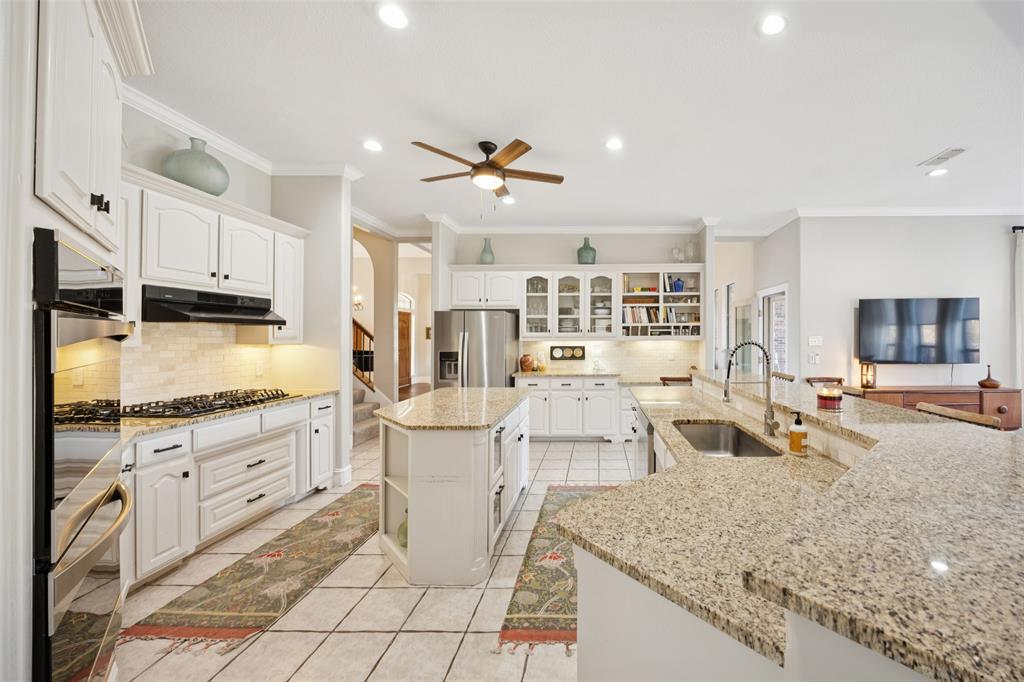 3611 Skinner Road Midlothian, TX 76065 - Photo 10 of 40 a large kitchen with kitchen island a stove a sink a dining table and chairs