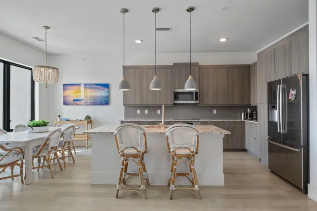 a kitchen with stainless steel appliances granite countertop a kitchen island a table and chairs