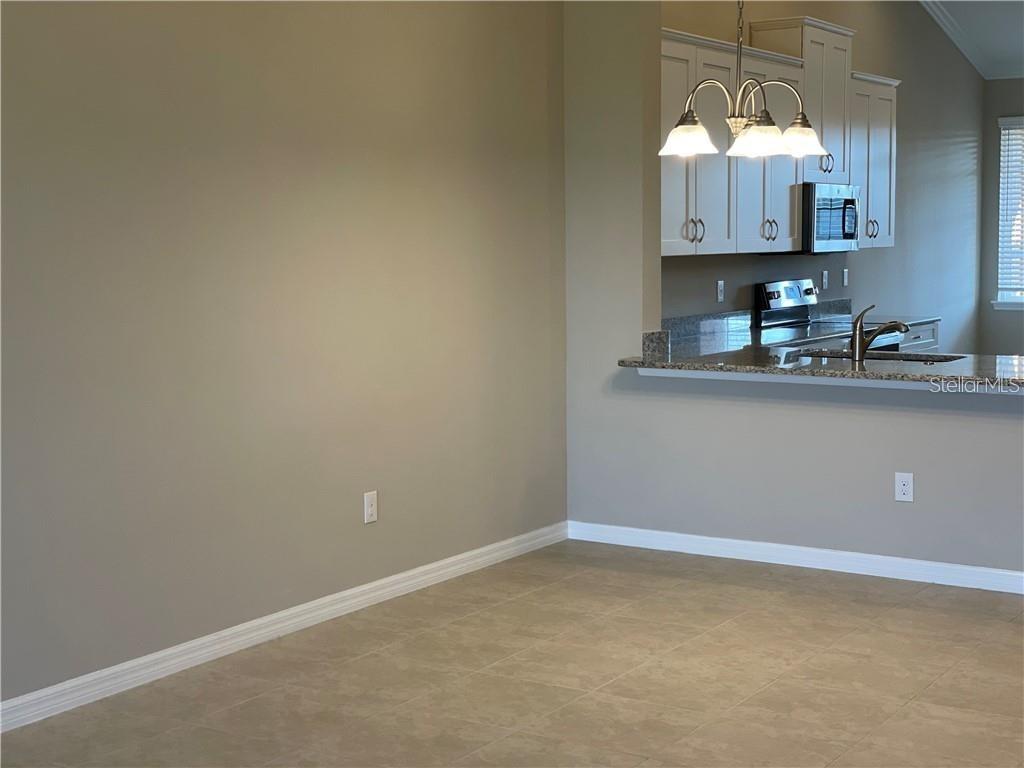 13823 Messina Loop, Unit 203 Bradenton, FL 34211 - Photo 3 of 15 a room with wooden floor and cabinets