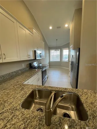a kitchen with a sink and a stove top oven