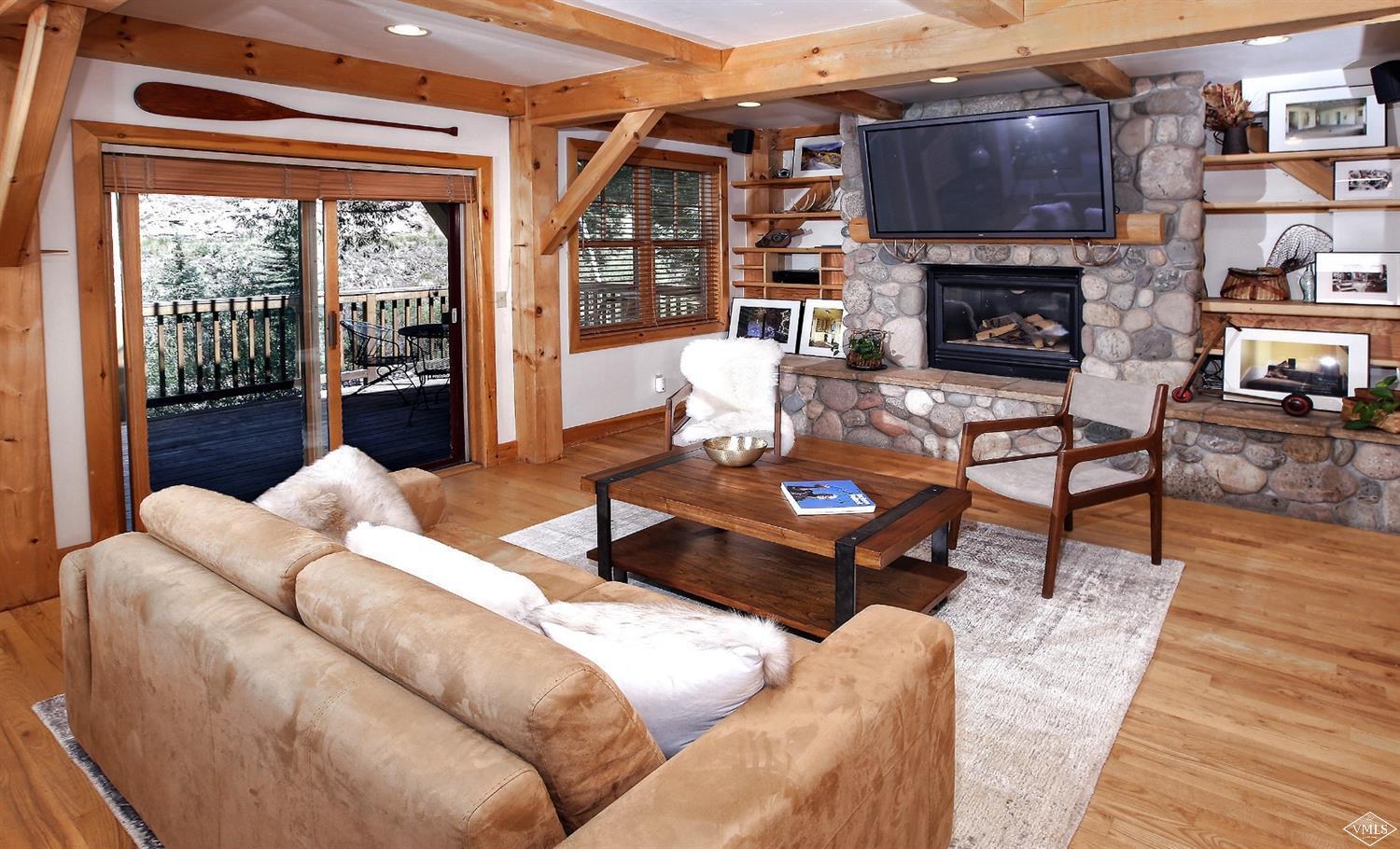 440 Eagle River Street Minturn, CO 81645 - Photo 2 of 24 a living room with furniture a fireplace and a floor to ceiling window