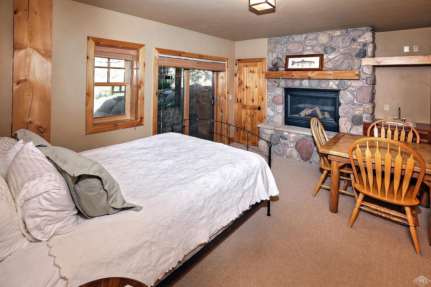 440 Eagle River Street Minturn, CO 81645 - Photo 22 of 24 a spacious bedroom with a bed and a fireplace