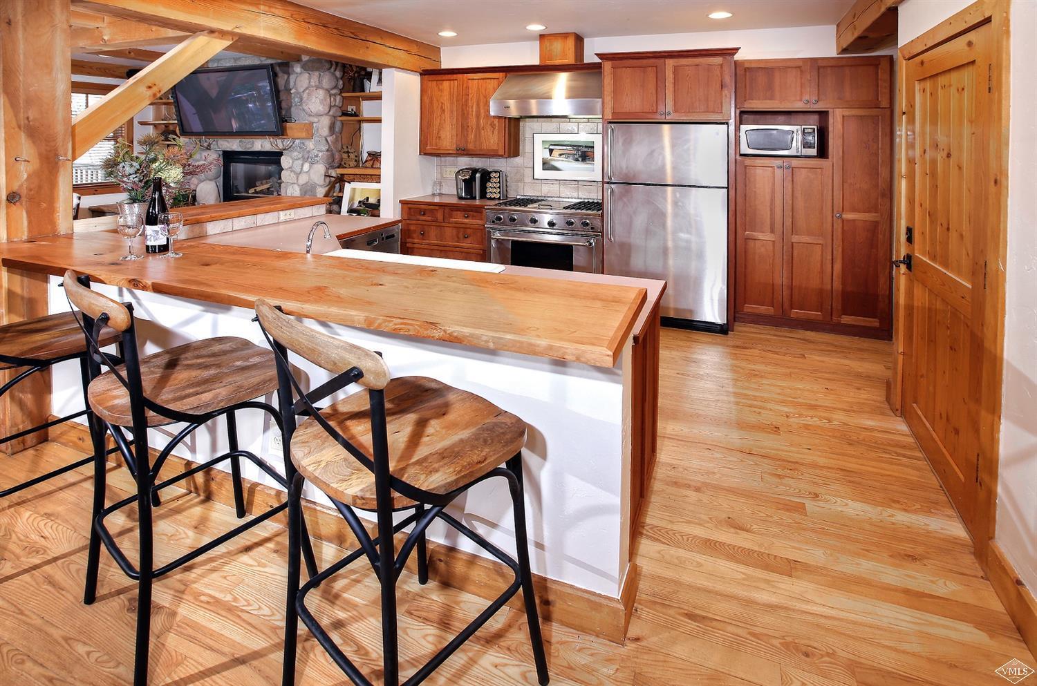 440 Eagle River Street Minturn, CO 81645 - Photo 7 of 24 a kitchen with stainless steel appliances granite countertop a table chairs microwave and sink