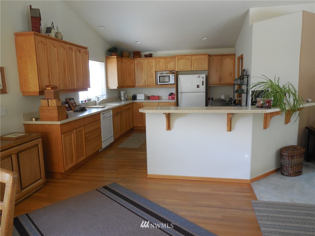 190 Booth Lane Sequim, WA 98382 - Photo 14 of 32 a kitchen with stainless steel appliances granite countertop a sink dishwasher stove top oven and cabinets with wooden floor