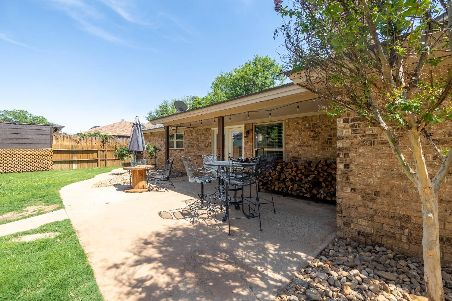 4522 79th Street Lubbock, TX 79424 - Photo 13 of 14 a view of a patio with table and chairs and potted plants with wooden fence