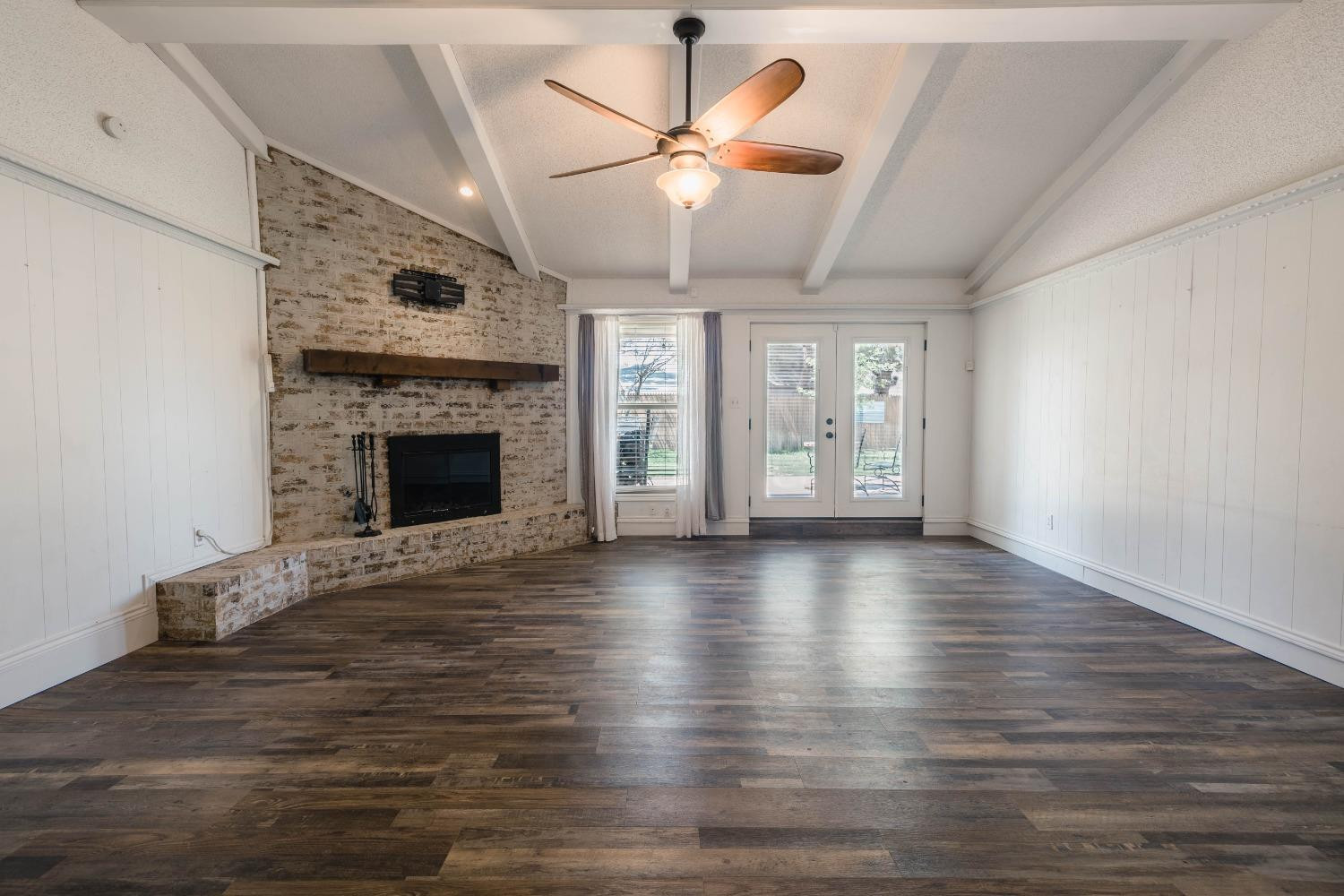 4522 79th Street Lubbock, TX 79424 - Photo 5 of 14 a view of an empty room with chandelier fan and wooden floor