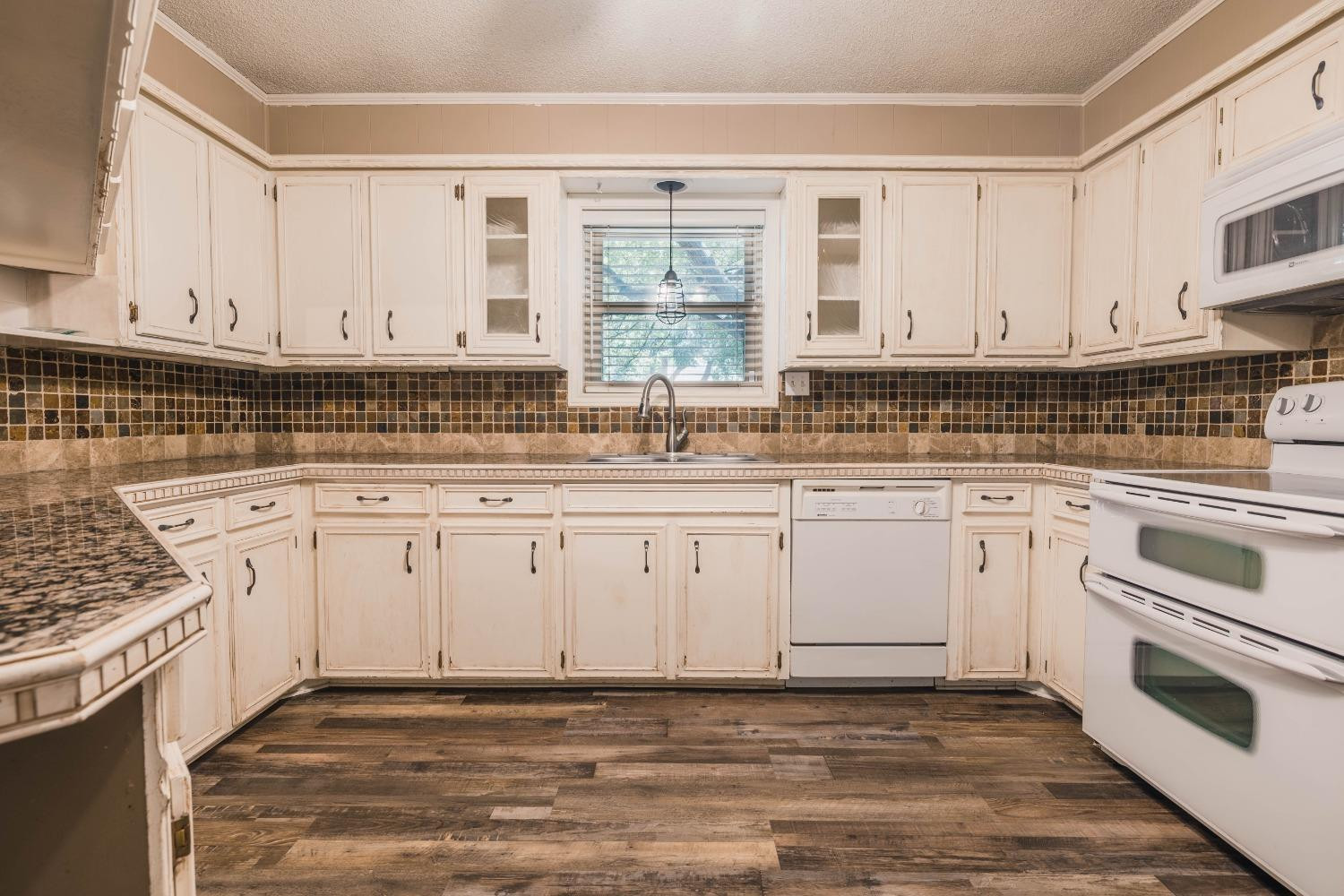 4522 79th Street Lubbock, TX 79424 - Photo 6 of 14 a kitchen with granite countertop white cabinets and white appliances