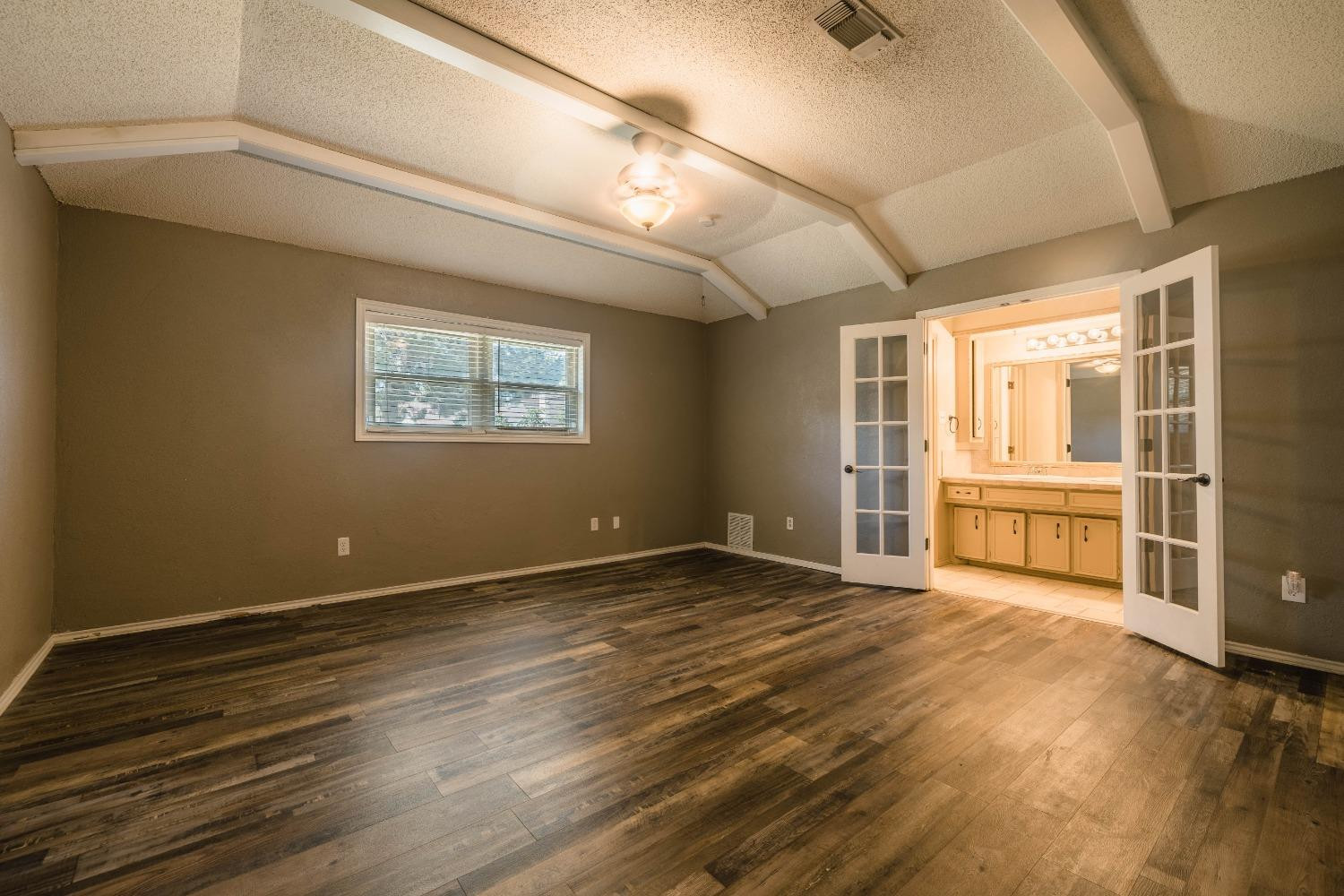 4522 79th Street Lubbock, TX 79424 - Photo 7 of 14 a view of an empty room with a window and wooden floor