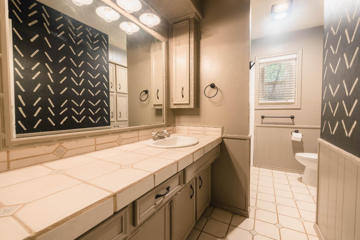 4522 79th Street Lubbock, TX 79424 - Photo 9 of 14 a bathroom with a sink and a mirror