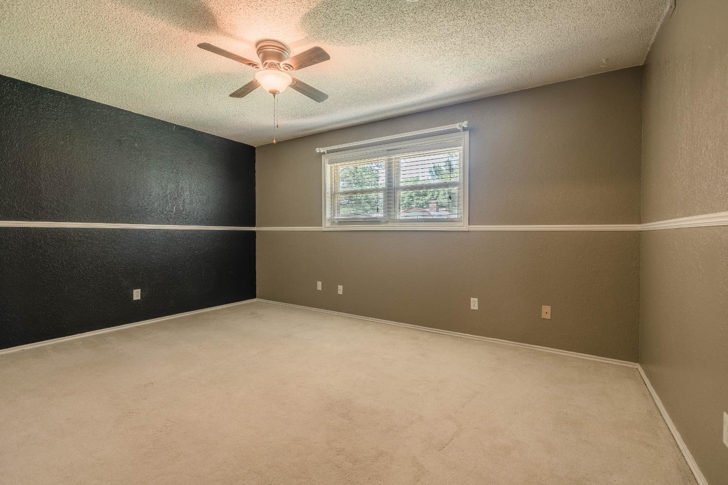 4522 79th Street Lubbock, TX 79424 - Photo 10 of 14 en empty room with windows and ceiling fan