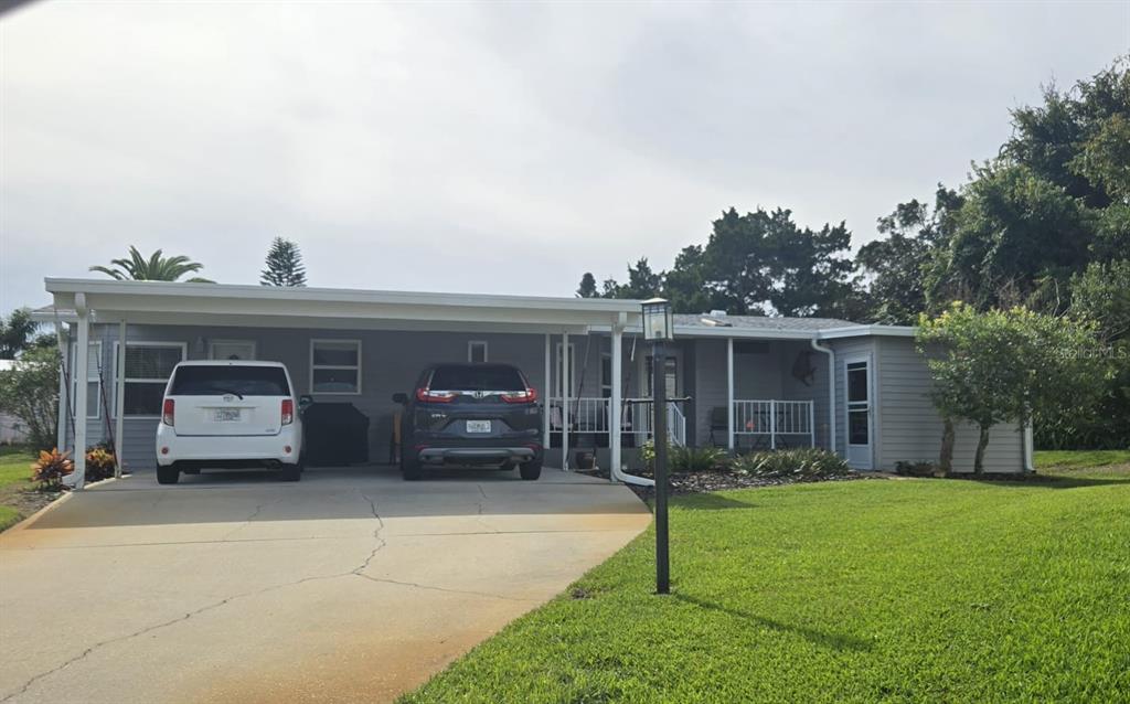 a view of a house with a yard and sitting area
