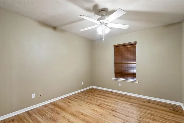 an empty room with a window and wooden floor
