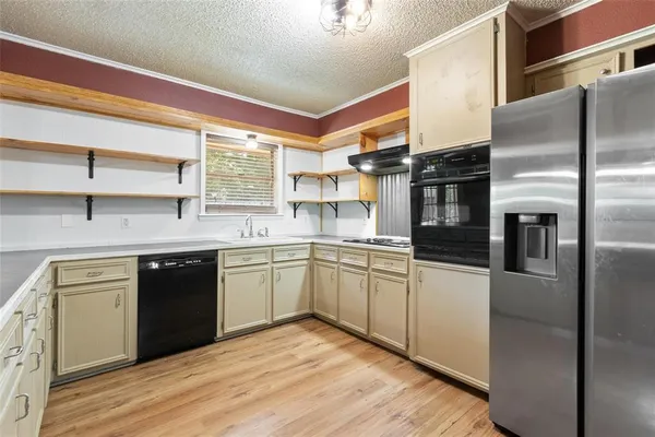 a kitchen with stainless steel appliances granite countertop a refrigerator a sink and white cabinets