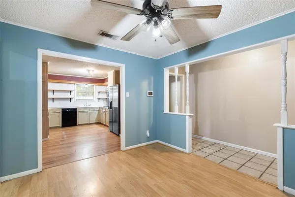 a view of a hallway with wooden floor and a kitchen
