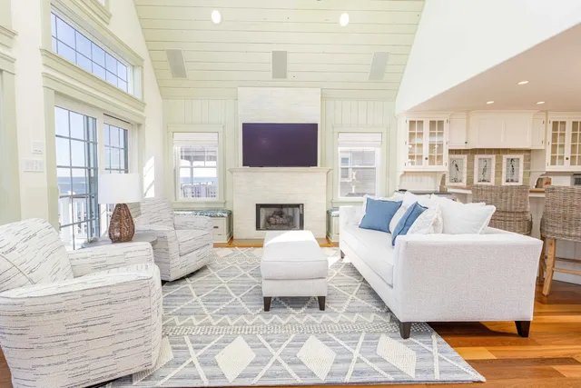 a living room with furniture a flat screen tv and a large window