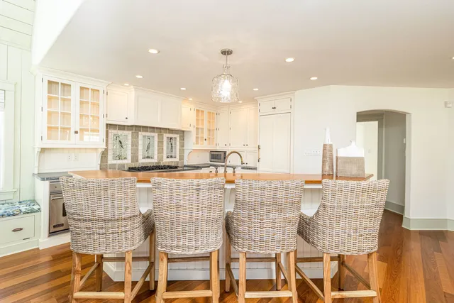 a dining hall with stainless steel appliances granite countertop a table and chairs
