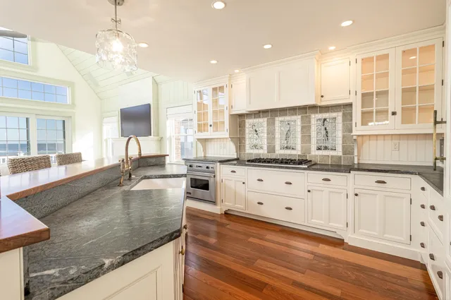 a large kitchen with stainless steel appliances granite countertop a stove and a sink