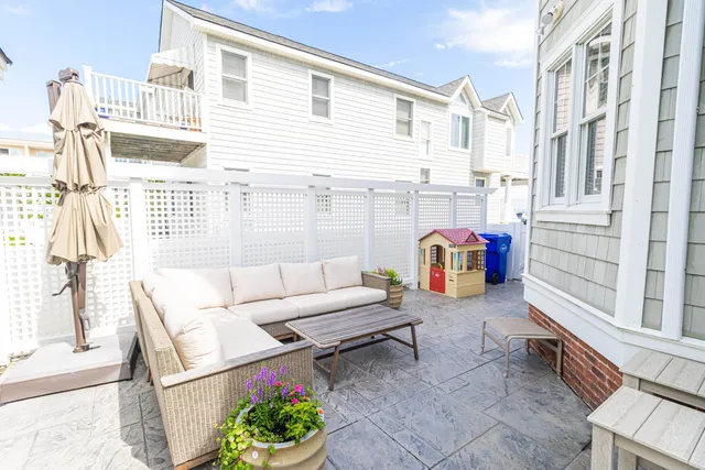 a view of a patio with couches table and chairs and potted plants