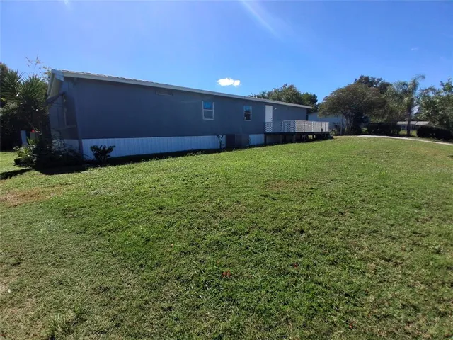 a view of a backyard with potted plants and large trees