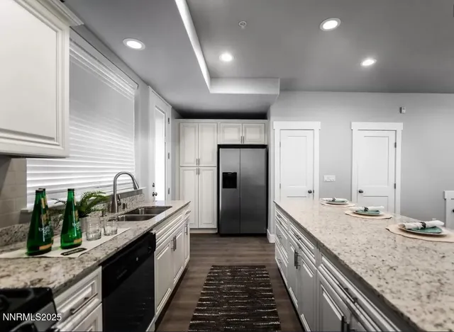 a large kitchen with stainless steel appliances granite countertop a lot of counter space and wooden floor