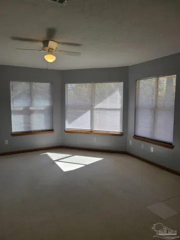 an empty room with windows and fireplace