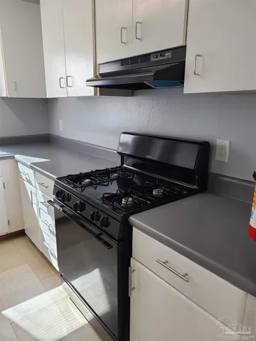 a stove top oven sitting inside of a kitchen