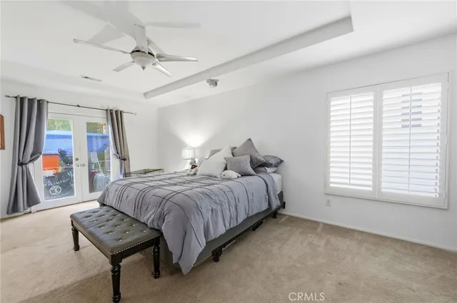 a bedroom with a bed next to a window and a flat screen tv