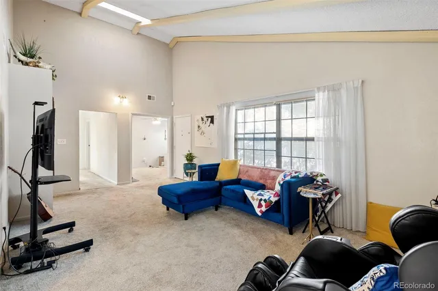 a living room with furniture a window and a flat screen tv