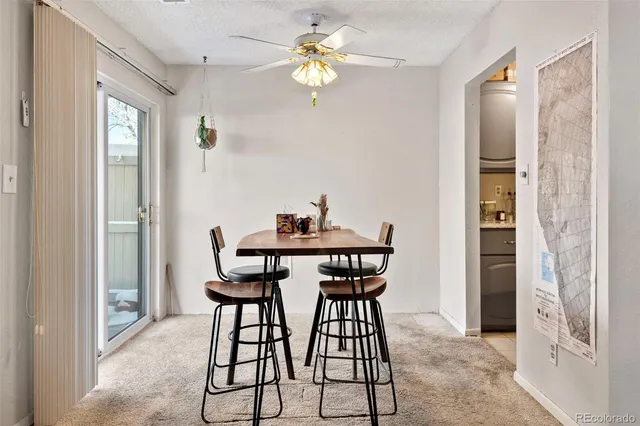 a dining room with furniture and chandelier fan