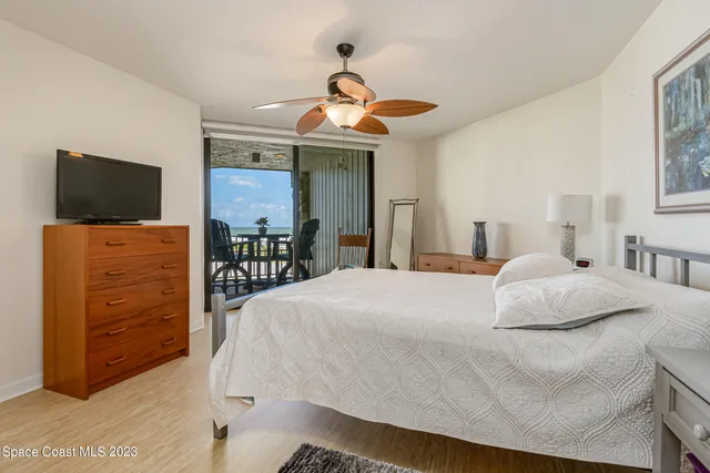 a bedroom with a bed and a flat tv screen on dresser