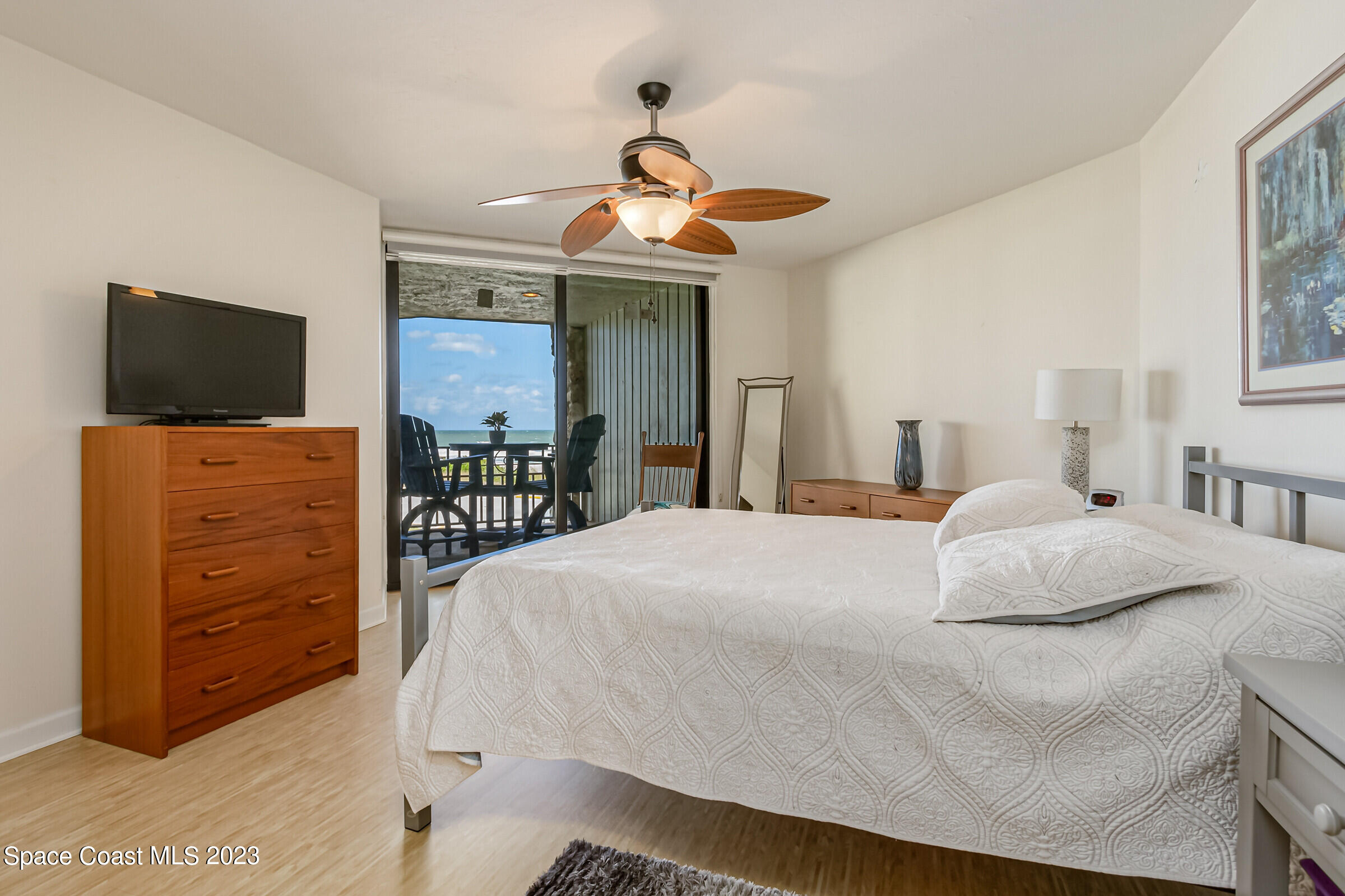 700 Wave Crest Avenue, Unit 202 Indialantic, FL 32903 - Photo 14 of 29 a bedroom with a bed and a flat tv screen on dresser