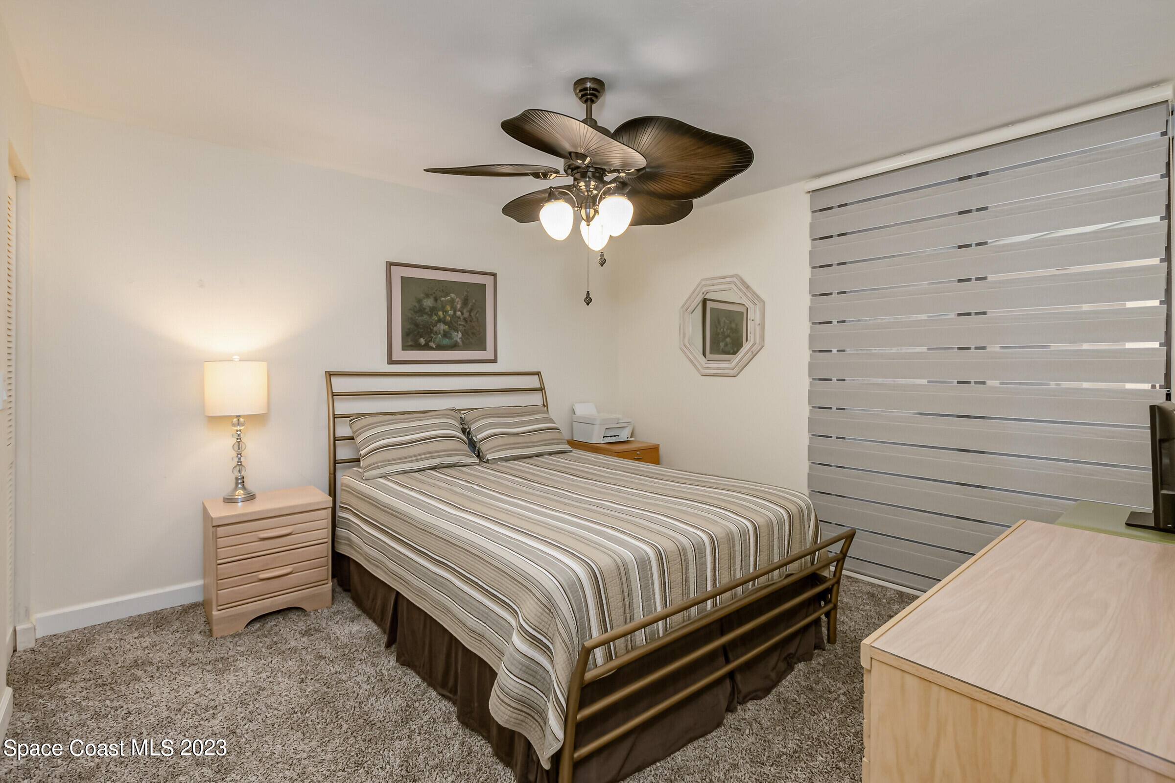 700 Wave Crest Avenue, Unit 202 Indialantic, FL 32903 - Photo 19 of 29 a bedroom with a bed and a chandelier