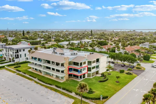 an aerial view of multi story residential apartment building with a yard