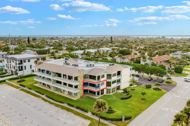 an aerial view of multi story residential apartment building with a yard