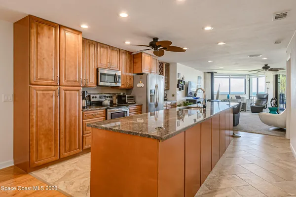 a large kitchen with granite countertop a large counter top stainless steel appliances and cabinets