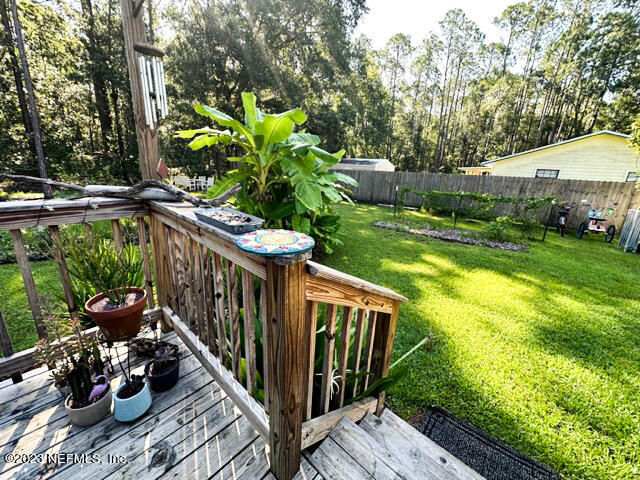 1504 Raiford Road Starke, FL 32091 - Photo 15 of 24 a balcony with couple of potted plants and large trees