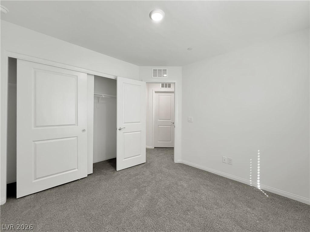 9984 Indigo Cliffs Street Las Vegas, NV 89141 - Photo 23 of 31 Unfurnished bedroom with visible vents, baseboards, a closet, and carpet flooring