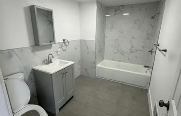 a bathroom with a sink mirror vanity and toilet
