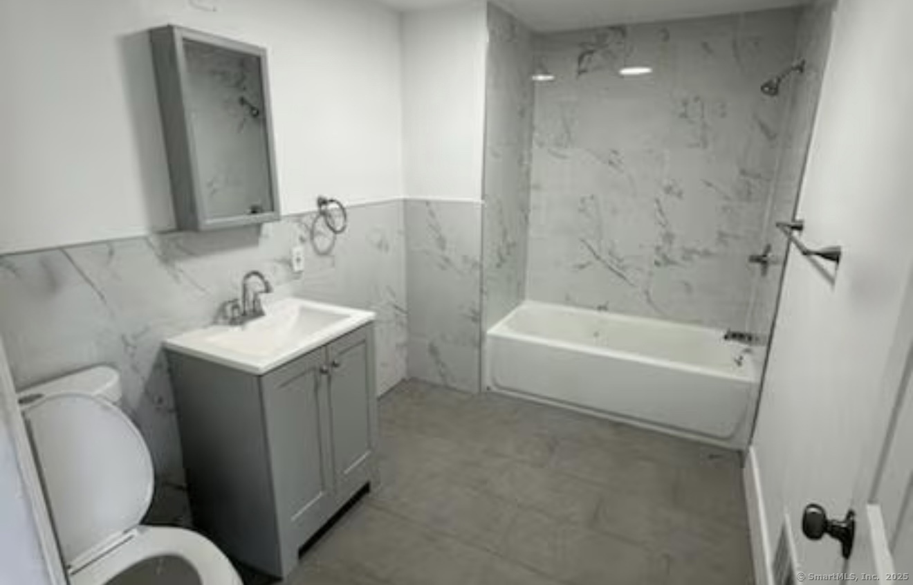 657 Maple Street, Unit 3 Bridgeport, CT 06608 - Photo 4 of 4 a bathroom with a sink mirror vanity and toilet