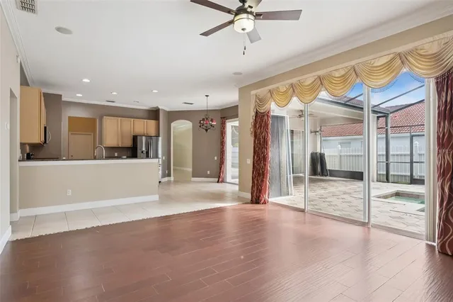 a view of a big room with wooden floor and a kitchen