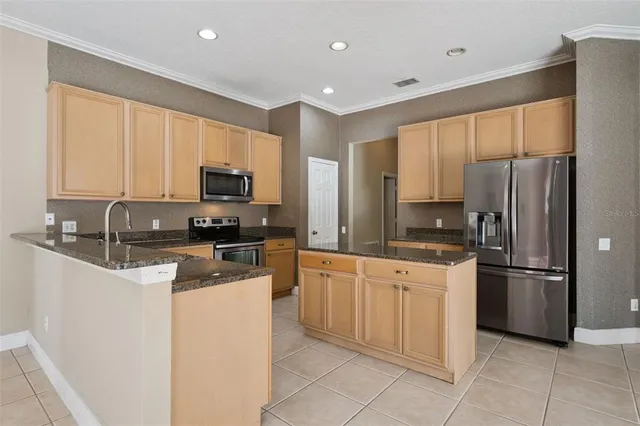 a kitchen with granite countertop a refrigerator and a sink