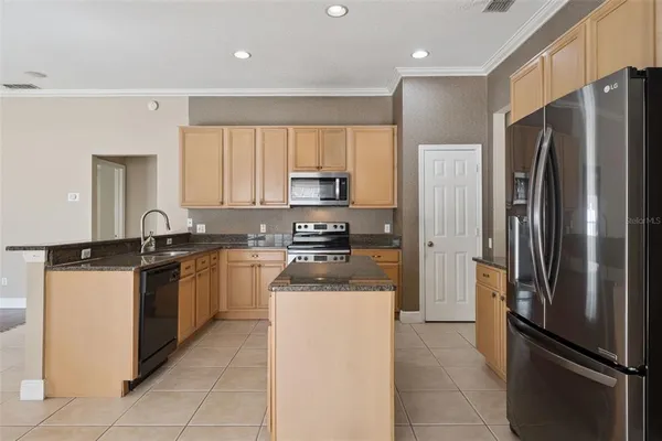 a kitchen with stainless steel appliances granite countertop a refrigerator and a stove top oven