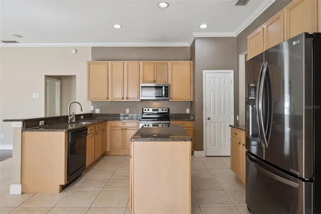 a kitchen with stainless steel appliances granite countertop a refrigerator and a stove top oven