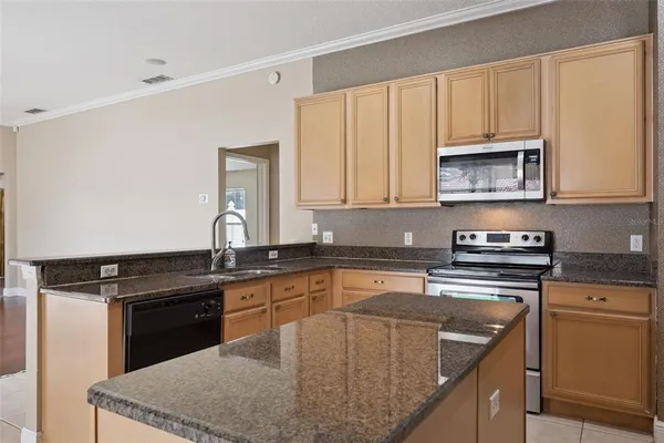 a kitchen with kitchen island granite countertop a stove sink and cabinets