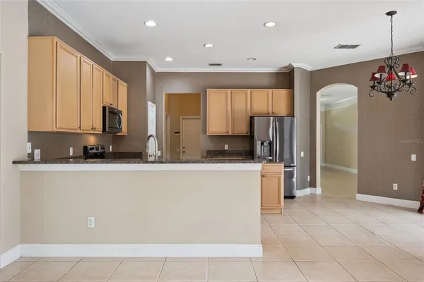 a view of kitchen with stainless steel appliances granite countertop a refrigerator and a sink