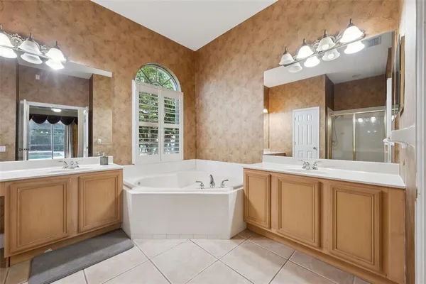 a large spacious bathroom with a large tub sink and mirror