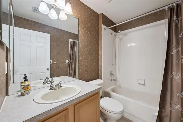 a bathroom with a sink toilet tub and shower