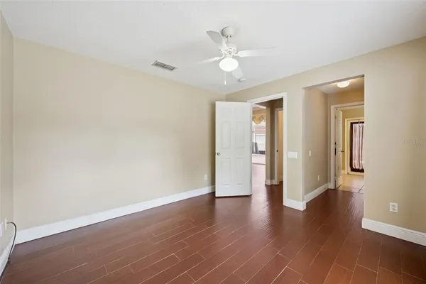 a view of a livingroom with wooden floor and ceiling fan